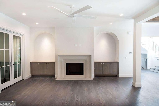 unfurnished living room with french doors, dark hardwood / wood-style floors, and ceiling fan