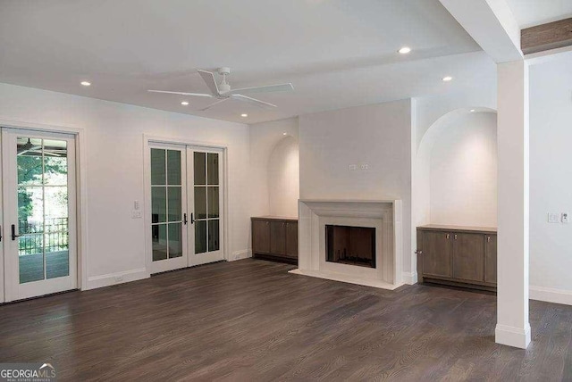 unfurnished living room featuring ceiling fan, dark wood-type flooring, and french doors