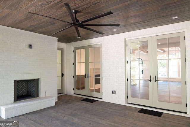 interior space with brick wall, french doors, ceiling fan, and hardwood / wood-style floors