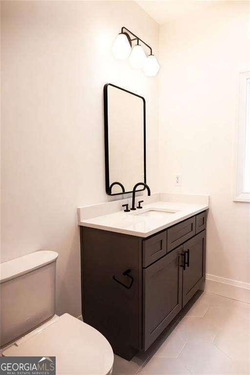 bathroom featuring toilet, vanity, and tile patterned floors