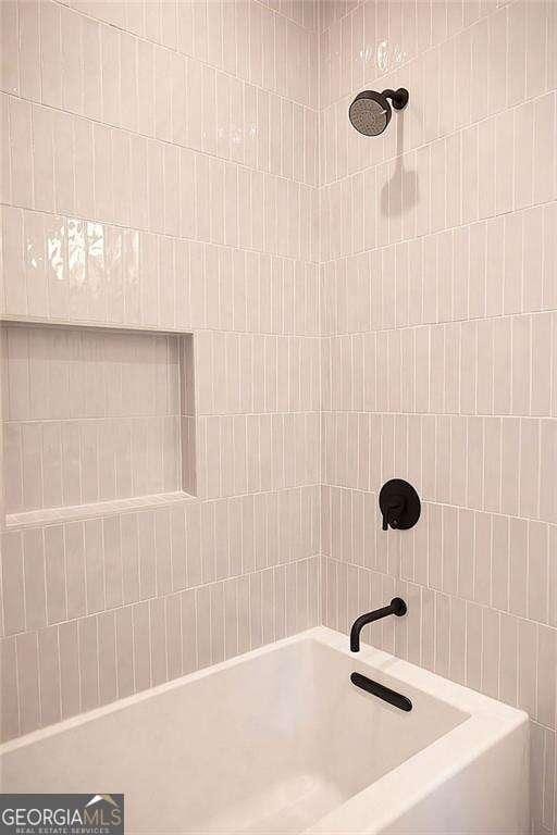 bathroom with tiled shower / bath combo