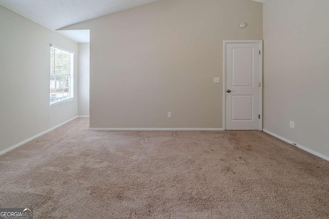 unfurnished room with lofted ceiling and light carpet