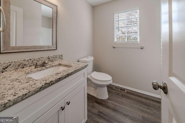 bathroom featuring vanity, wood-type flooring, and toilet