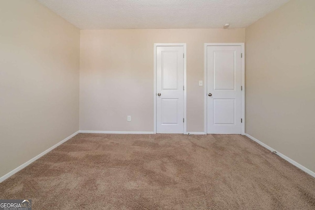 spare room featuring carpet flooring and a textured ceiling