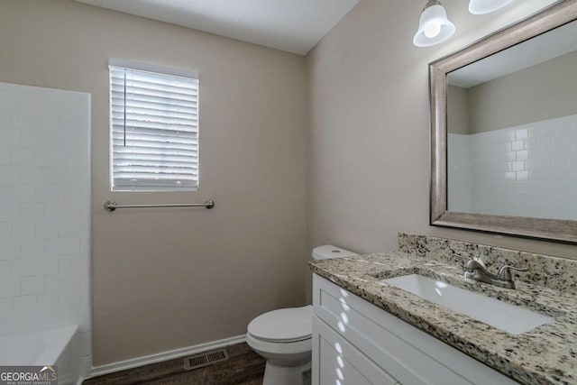 full bathroom featuring hardwood / wood-style floors, vanity, toilet, and shower / washtub combination