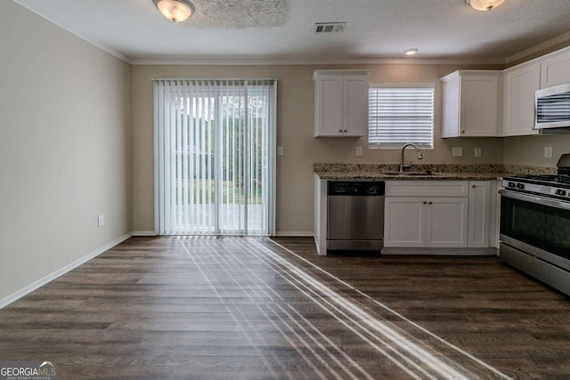 kitchen with stainless steel appliances, dark wood-type flooring, sink, stone countertops, and white cabinets