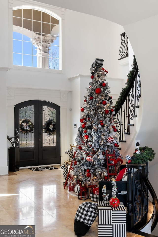 foyer entrance featuring french doors and a towering ceiling