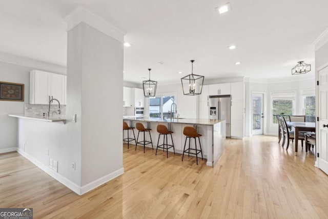 kitchen featuring kitchen peninsula, white cabinets, and plenty of natural light