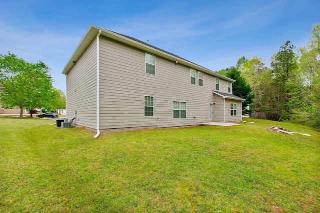 rear view of house with central AC, a patio area, and a lawn