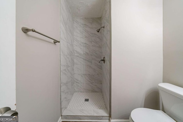 bathroom with tiled shower and toilet