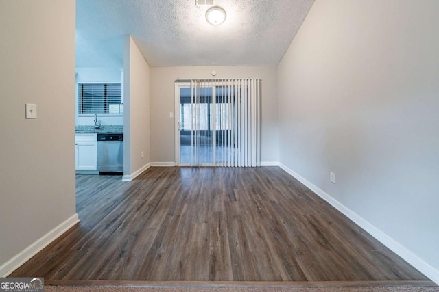 spare room featuring sink, dark hardwood / wood-style flooring, and a textured ceiling