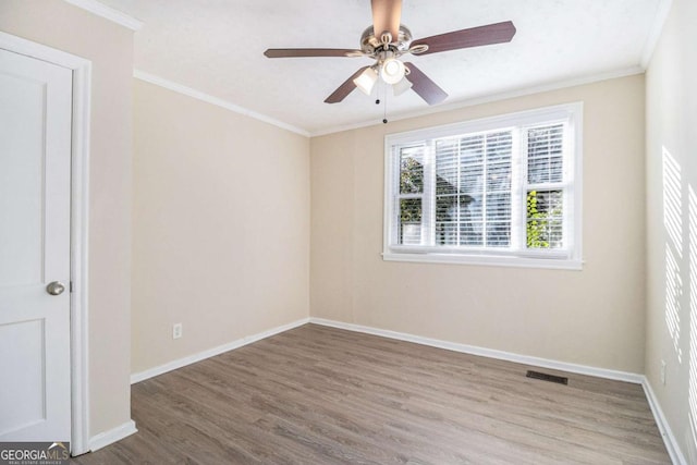 unfurnished room featuring hardwood / wood-style flooring, ceiling fan, and crown molding