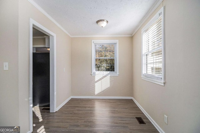 spare room with plenty of natural light, dark hardwood / wood-style flooring, and ornamental molding