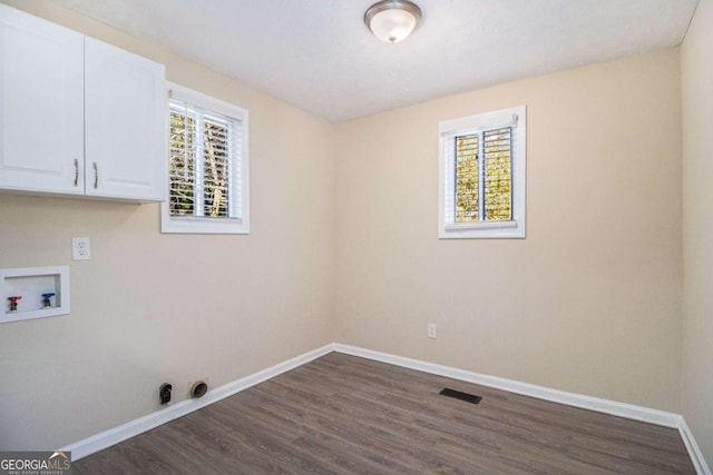 laundry area with gas dryer hookup, dark hardwood / wood-style flooring, cabinets, and washer hookup