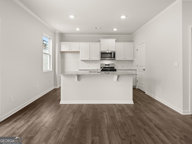 kitchen featuring light stone countertops, dark hardwood / wood-style flooring, a center island with sink, white cabinets, and appliances with stainless steel finishes