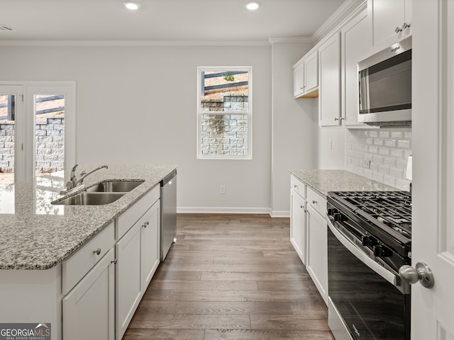 kitchen with white cabinets, sink, light stone countertops, dark hardwood / wood-style flooring, and stainless steel appliances