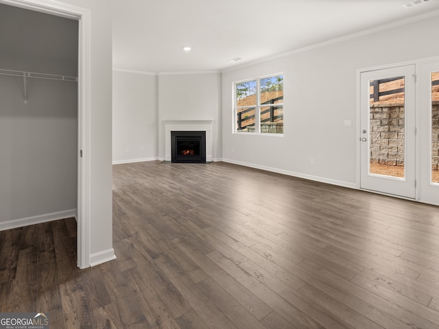 unfurnished living room featuring ornamental molding and dark wood-type flooring