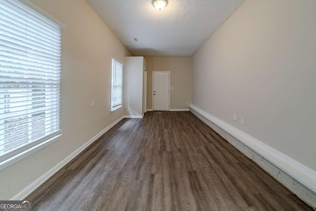 unfurnished room with dark hardwood / wood-style floors and a textured ceiling