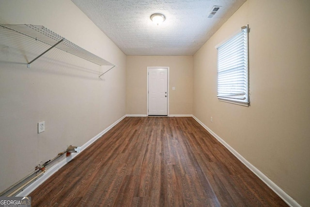 interior space with a textured ceiling and dark wood-type flooring