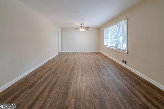 empty room with dark hardwood / wood-style floors and ceiling fan