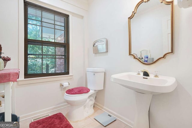 bathroom featuring tile patterned flooring, plenty of natural light, toilet, and sink