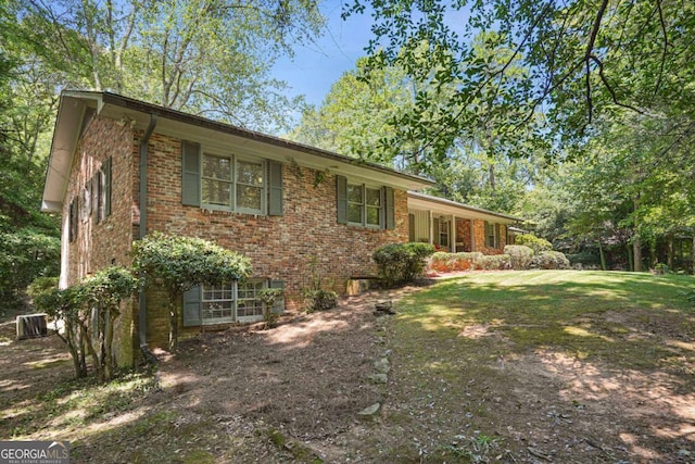 exterior space with central AC unit and a yard