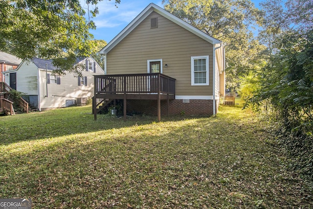 rear view of property with a yard and a deck