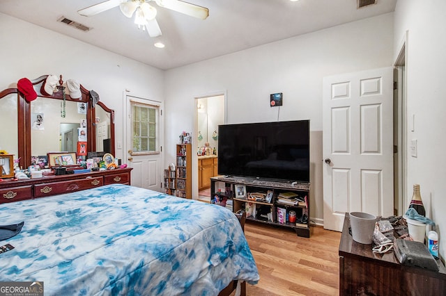 bedroom with connected bathroom, ceiling fan, and light wood-type flooring