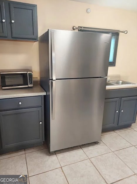 kitchen featuring sink, light tile patterned flooring, and appliances with stainless steel finishes