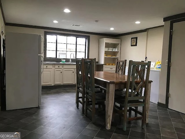 dining area featuring crown molding, sink, and washer / dryer