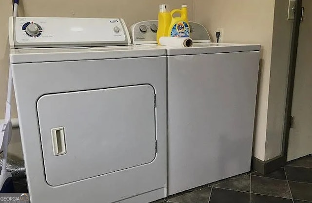 clothes washing area with dark tile patterned flooring and independent washer and dryer