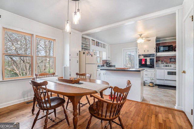 dining room featuring light wood-type flooring, ceiling fan, and ornamental molding