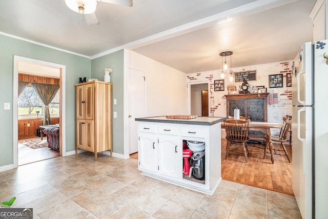 kitchen with light wood-type flooring, ceiling fan, white fridge, white cabinetry, and hanging light fixtures