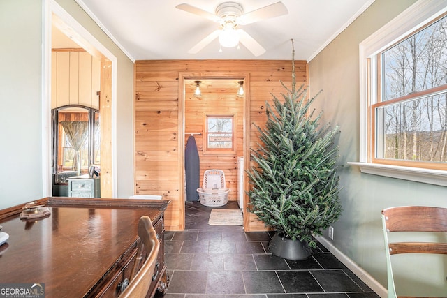 interior space featuring ceiling fan, crown molding, and wood walls