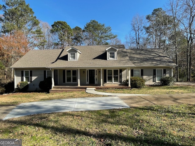 new england style home featuring covered porch and a front lawn