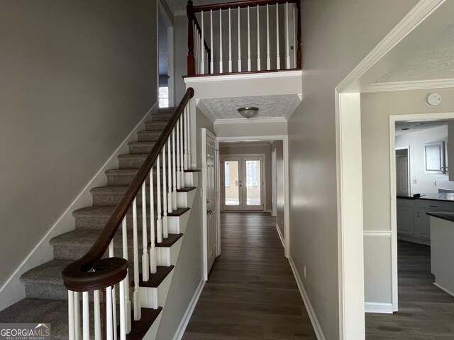 stairs featuring wood-type flooring, ornamental molding, and french doors