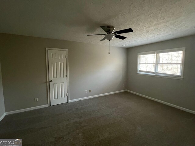 carpeted spare room featuring ceiling fan and a textured ceiling