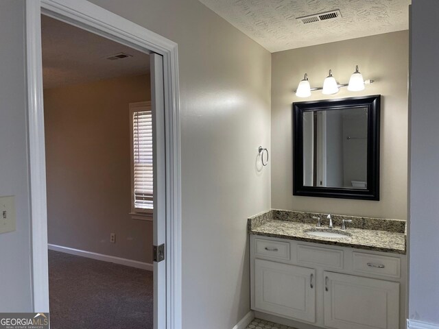 bathroom with vanity and a textured ceiling