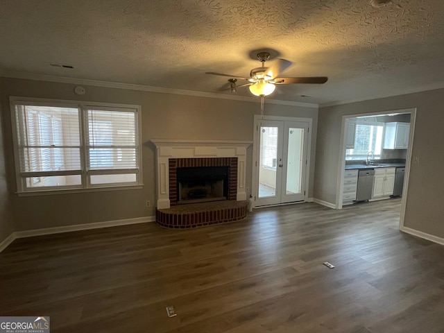 unfurnished living room featuring dark hardwood / wood-style flooring, a textured ceiling, and ornamental molding