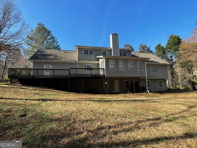 rear view of property featuring a lawn and a wooden deck