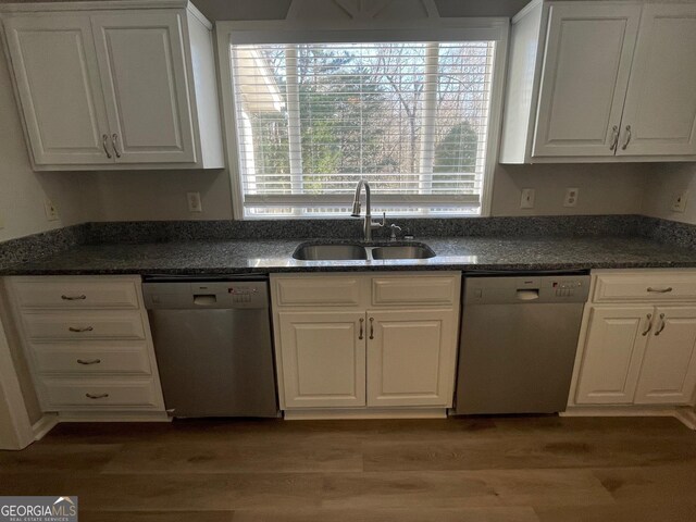 kitchen featuring wood-type flooring, white cabinetry, stainless steel dishwasher, and sink