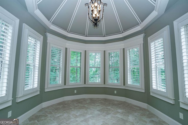 unfurnished sunroom featuring a notable chandelier, a healthy amount of sunlight, and vaulted ceiling