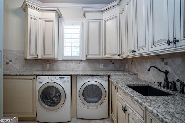 laundry room with washing machine and clothes dryer, cabinets, and sink