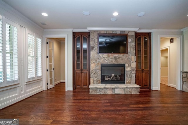 unfurnished living room featuring a fireplace, dark hardwood / wood-style floors, and ornamental molding