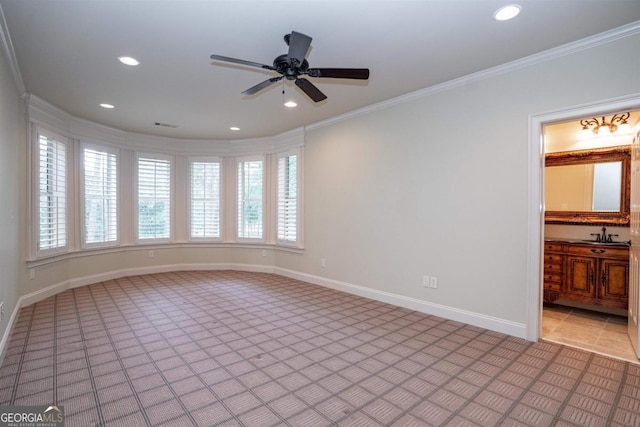 empty room featuring light tile patterned flooring, ceiling fan, crown molding, and sink