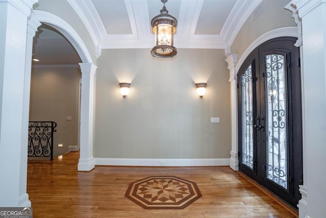 foyer entrance featuring french doors, an inviting chandelier, crown molding, and wood-type flooring