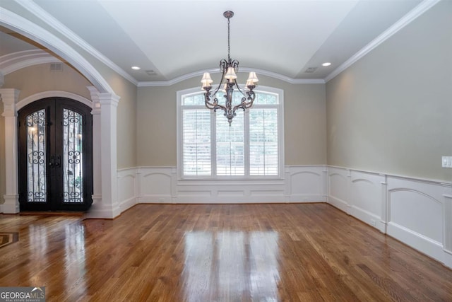 interior space featuring a chandelier, wood-type flooring, and ornamental molding