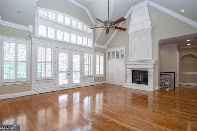 unfurnished living room featuring ceiling fan, plenty of natural light, and high vaulted ceiling