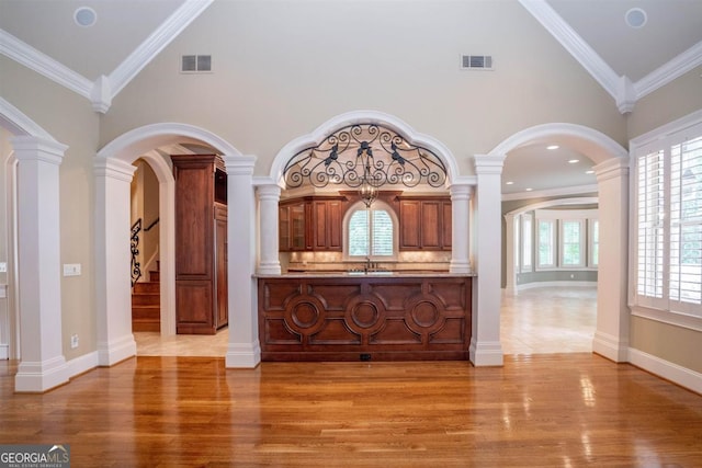 interior space with light wood-type flooring, ornamental molding, and high vaulted ceiling