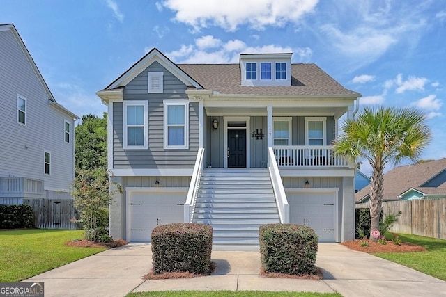 view of front of home with a front yard, a porch, and a garage